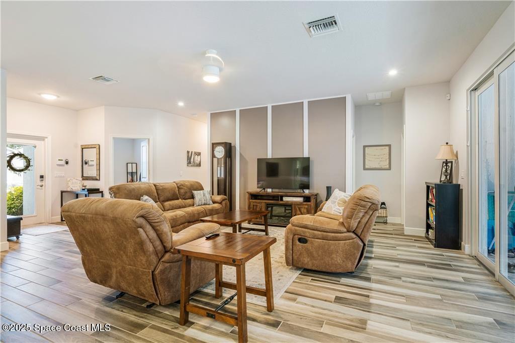 Undisclosed Address Vero Beach, FL 32966 - Photo 16 of 36 a living room with furniture a flat screen tv and a wooden floor