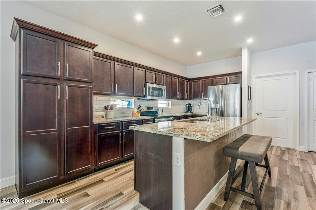 Undisclosed Address Vero Beach, FL 32966 - Photo 22 of 36 a kitchen with stainless steel appliances granite countertop a refrigerator stove microwave and sink