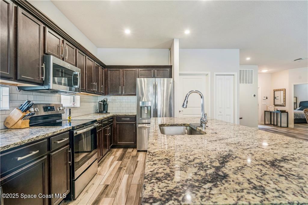 Undisclosed Address Vero Beach, FL 32966 - Photo 23 of 36 a kitchen with stainless steel appliances granite countertop a stove refrigerator sink and cabinets