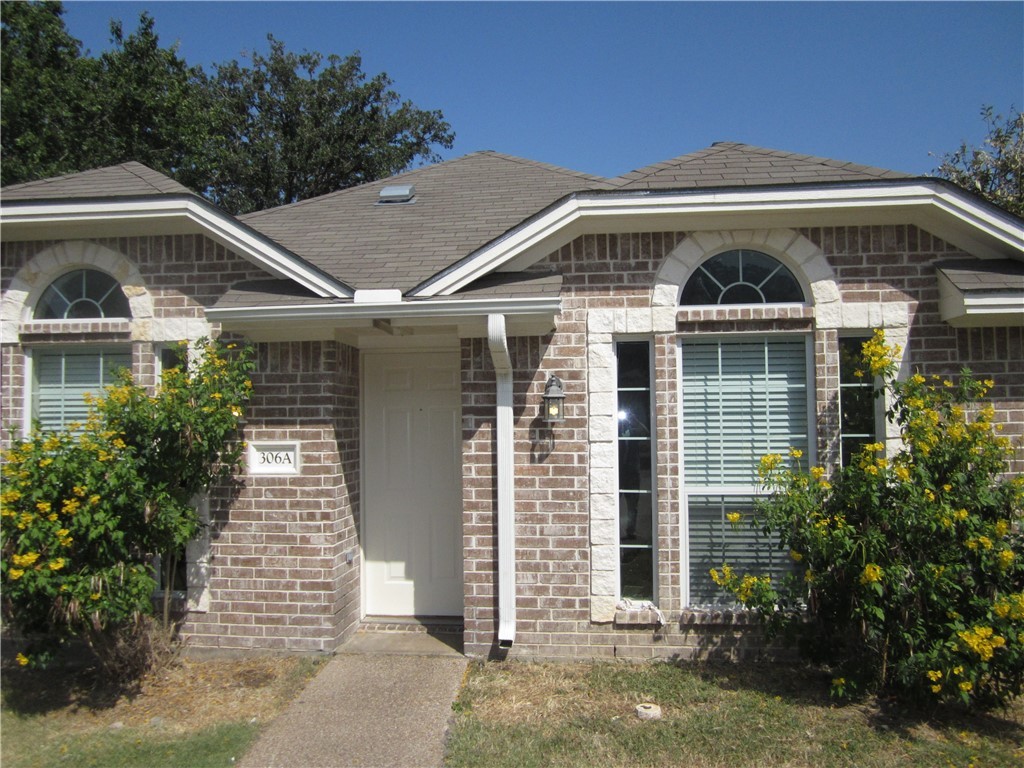 306 Fairway Drive, Unit A Bryan, TX 77801 - Photo 1 of 11 a front view of a house with a yard