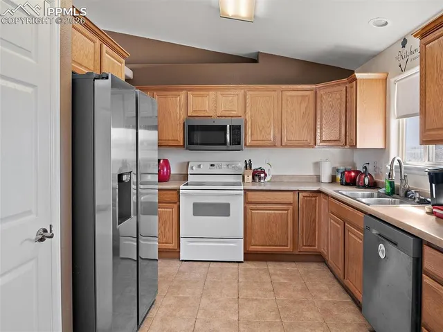 a kitchen with cabinets stainless steel appliances and a window