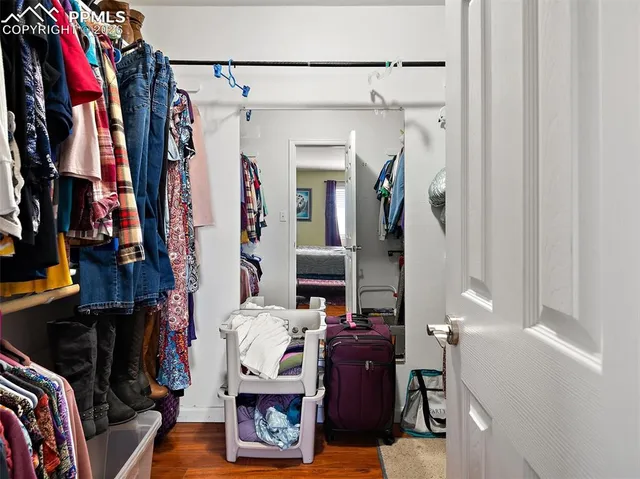 a view of walk in closet with clothes and shoes