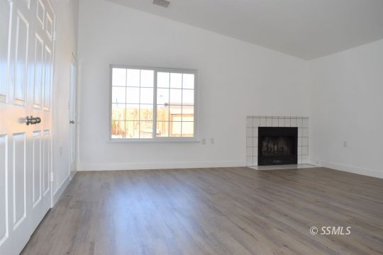 1132 West Robert Avenue Ridgecrest, CA 93555 - Photo 25 of 38 an empty room with wooden floor and windows