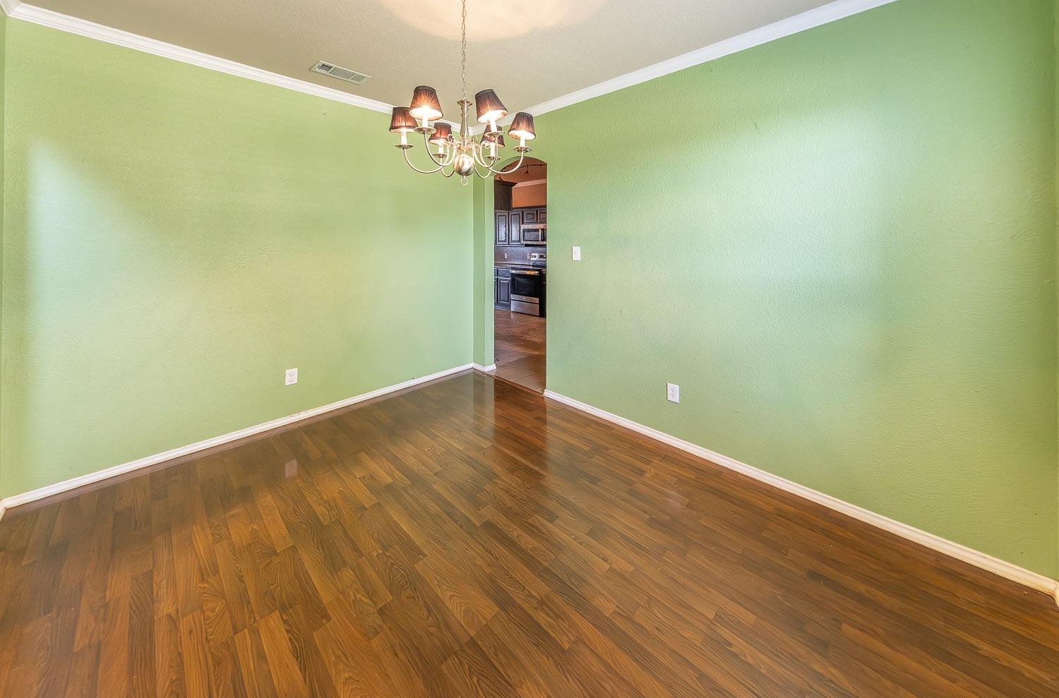5211 Harvard Street Lubbock, TX 79416 - Photo 11 of 31 a view of a room with wooden floor and chandelier