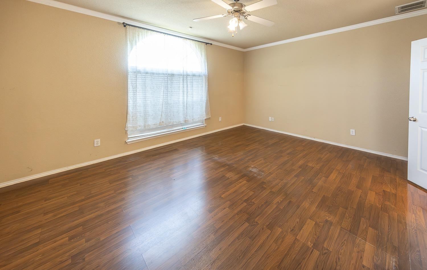 5211 Harvard Street Lubbock, TX 79416 - Photo 13 of 31 an empty room with wooden floor and windows