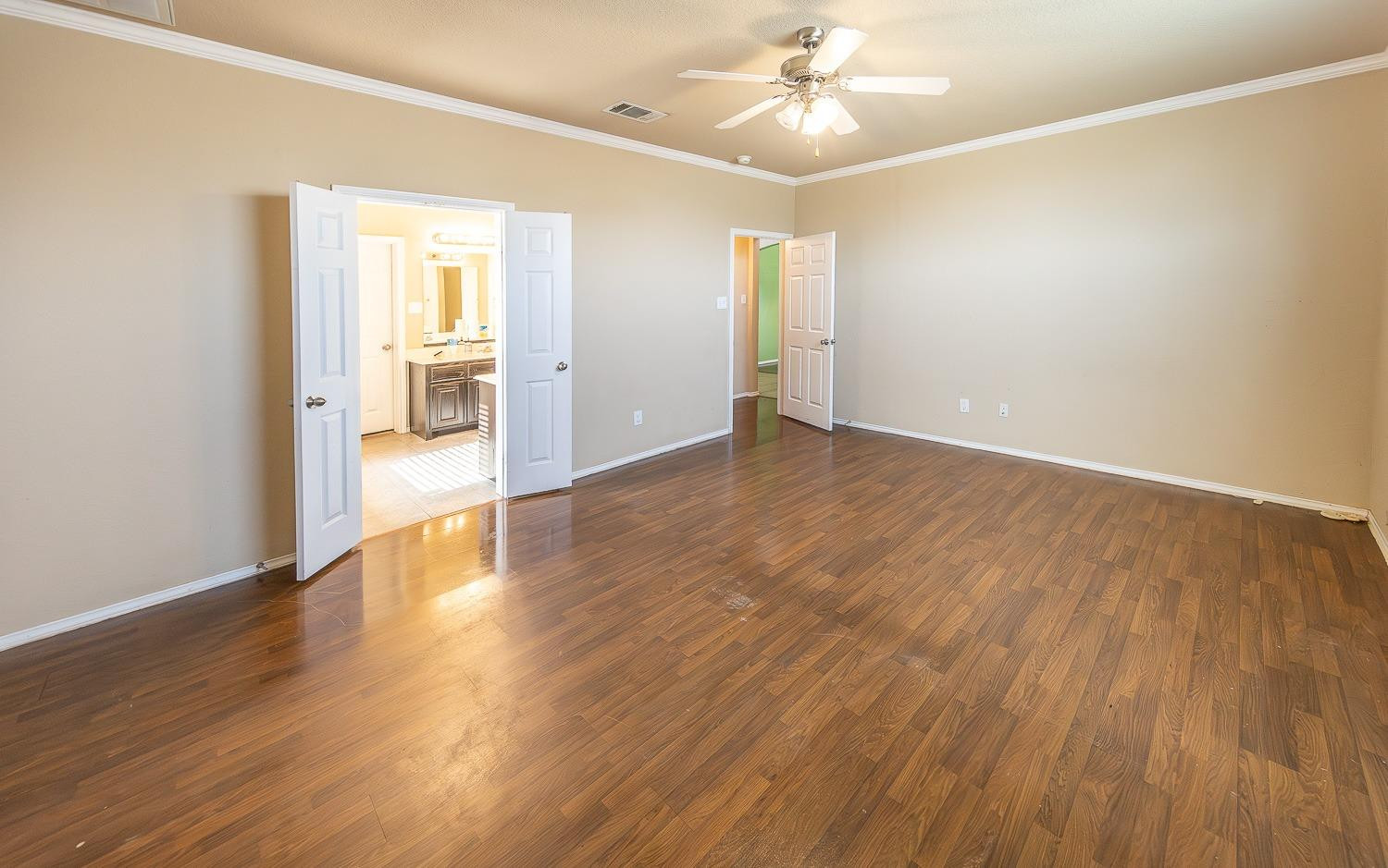 5211 Harvard Street Lubbock, TX 79416 - Photo 14 of 31 an empty room with wooden floor chandelier fan and windows