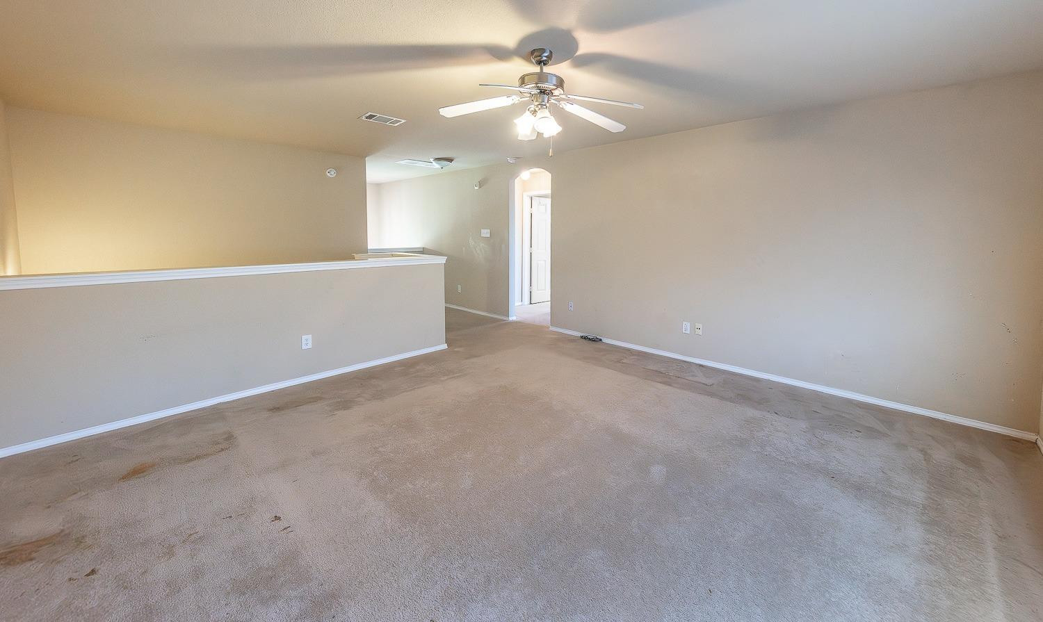 5211 Harvard Street Lubbock, TX 79416 - Photo 21 of 31 an empty room with a chandelier fan and windows
