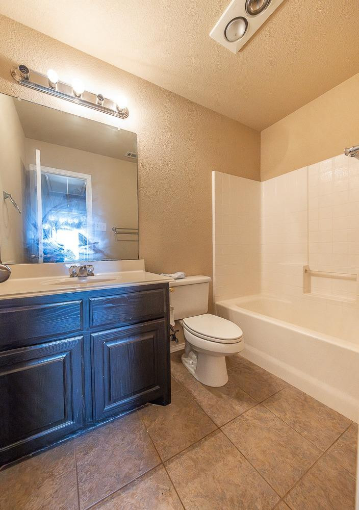 5211 Harvard Street Lubbock, TX 79416 - Photo 22 of 31 a bathroom with a toilet a sink and a bathtub