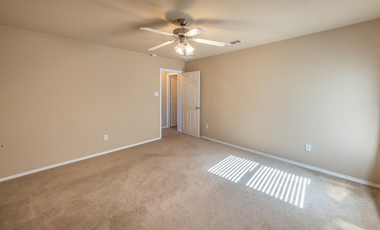5211 Harvard Street Lubbock, TX 79416 - Photo 24 of 31 an empty room with a chandelier fan and windows