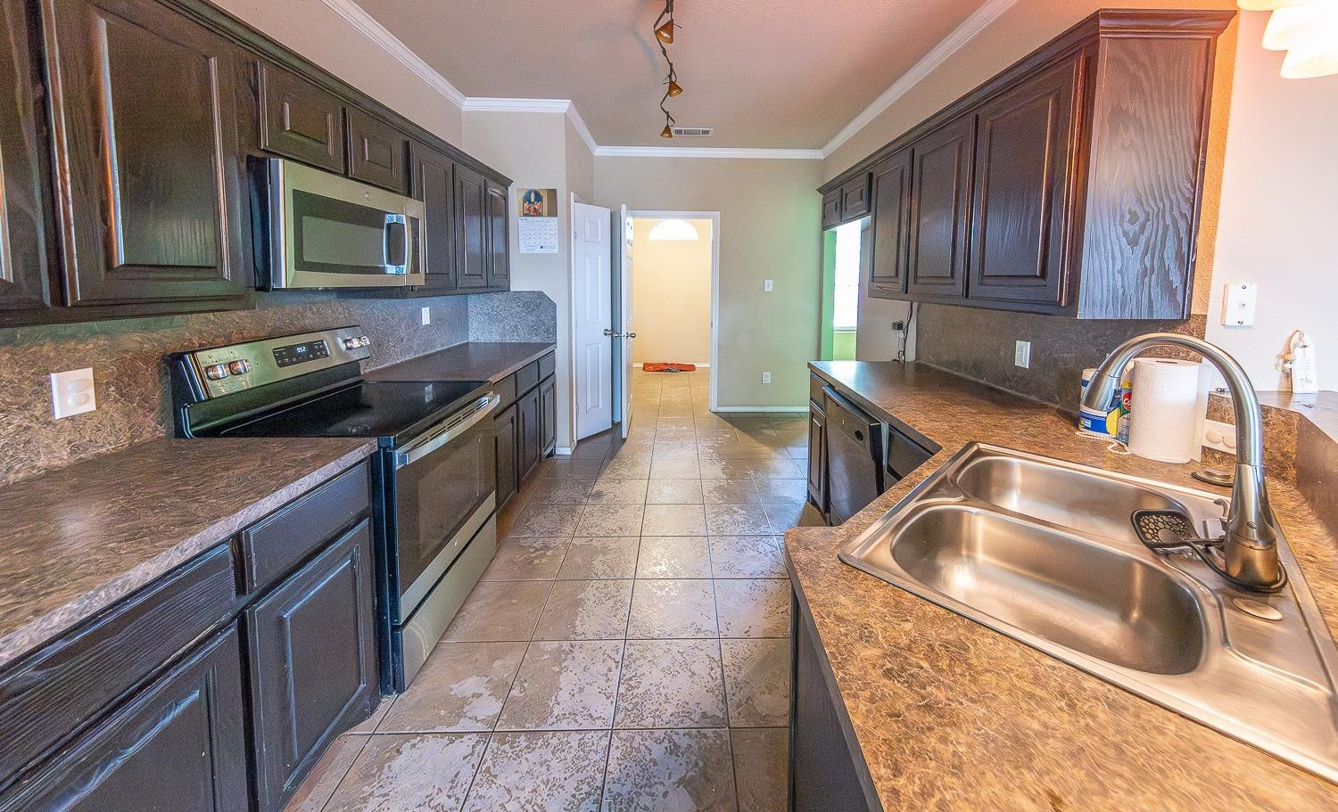 5211 Harvard Street Lubbock, TX 79416 - Photo 3 of 31 a kitchen with a sink stove top oven and microwave
