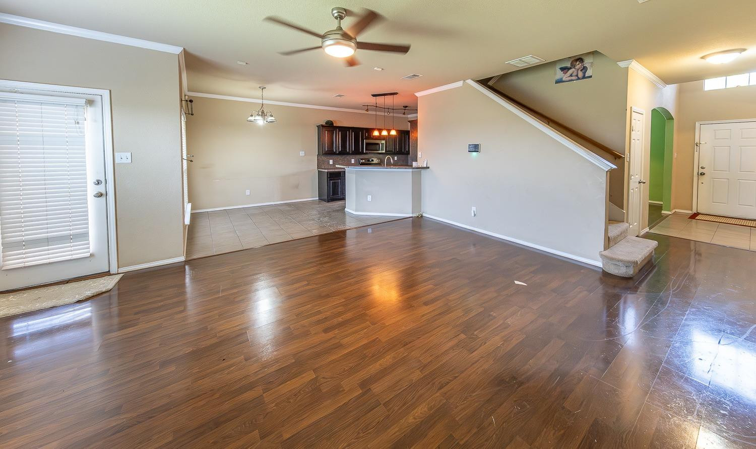 5211 Harvard Street Lubbock, TX 79416 - Photo 6 of 31 a view of a livingroom with wooden floor and a ceiling fan