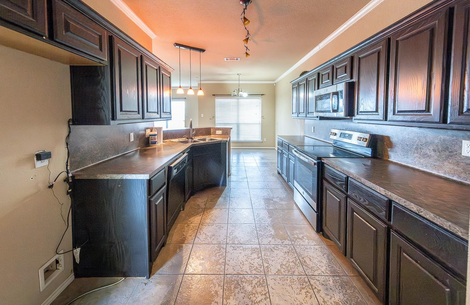 5211 Harvard Street Lubbock, TX 79416 - Photo 9 of 31 a kitchen with stainless steel appliances granite countertop a stove a sink and a refrigerator
