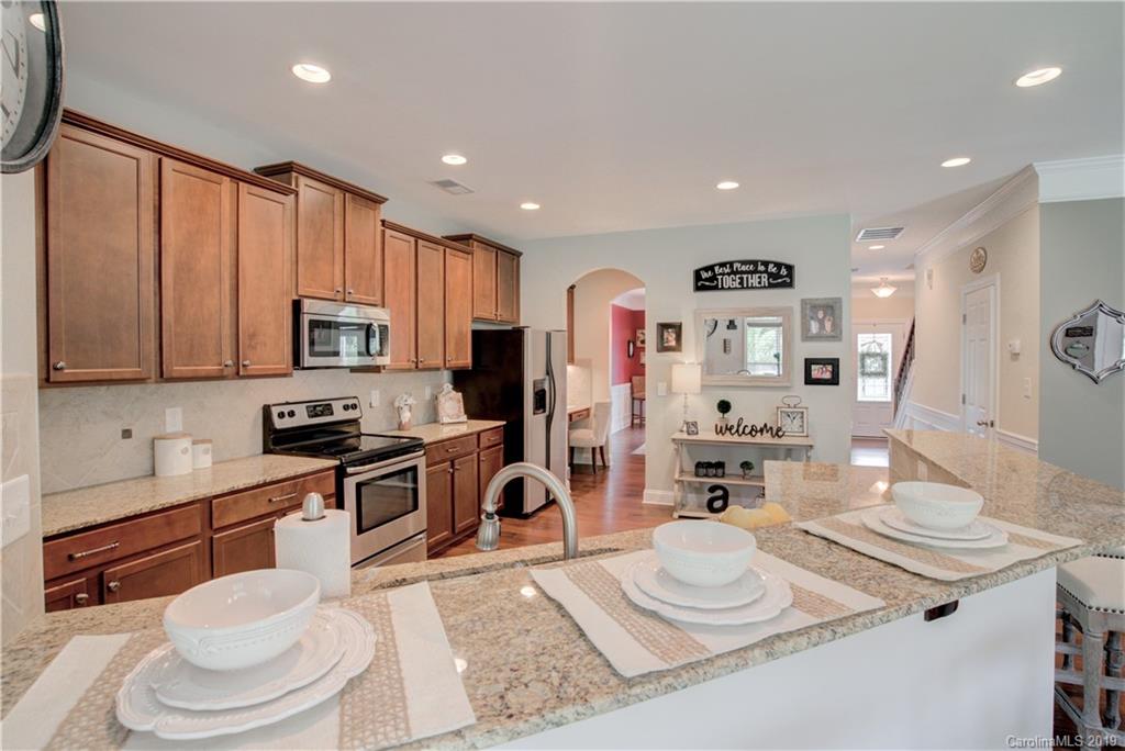 1200 Ridgehaven Road Waxhaw, NC 28173 - Photo 13 of 47 a kitchen with stainless steel appliances kitchen island granite countertop a sink and cabinets