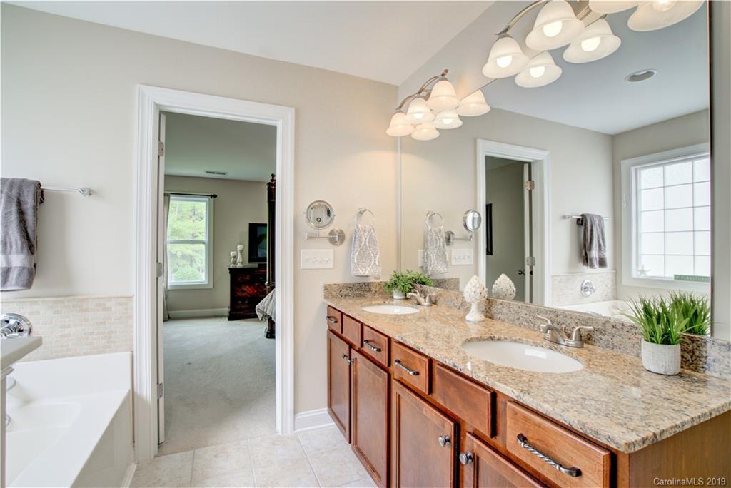 1200 Ridgehaven Road Waxhaw, NC 28173 - Photo 27 of 47 a bathroom with a granite countertop sink a large mirror and a bathtub