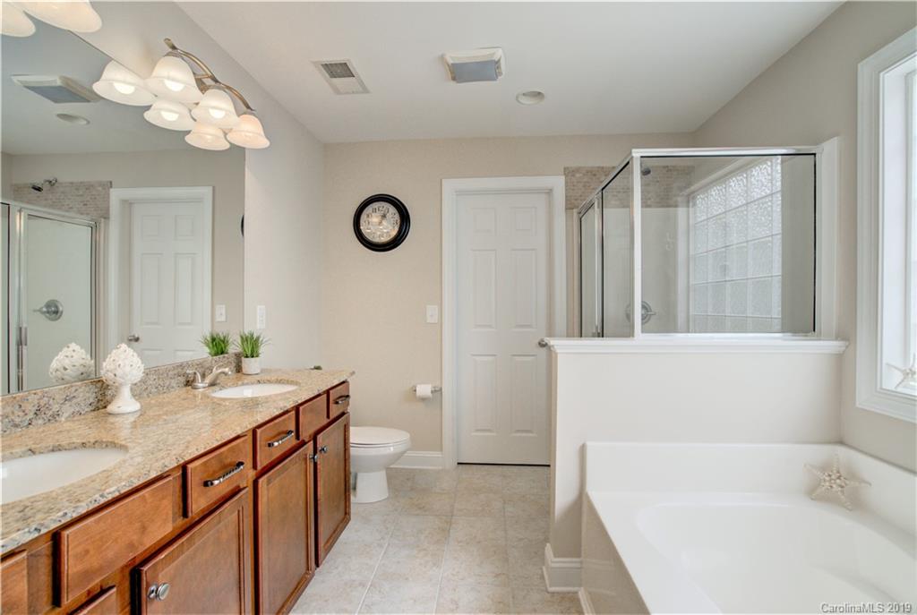1200 Ridgehaven Road Waxhaw, NC 28173 - Photo 28 of 47 a bathroom with a tub a sink and a large mirror