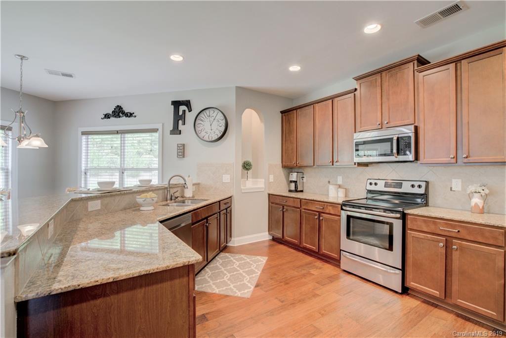 1200 Ridgehaven Road Waxhaw, NC 28173 - Photo 8 of 47 a large kitchen with stainless steel appliances granite countertop a stove a sink and a microwave