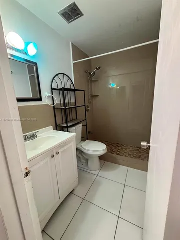 a kitchen with a sink cabinets and wooden floor