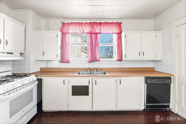 a kitchen with a sink a stove and cabinets