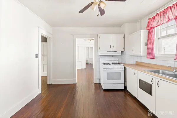 a kitchen with wooden floors and white appliances