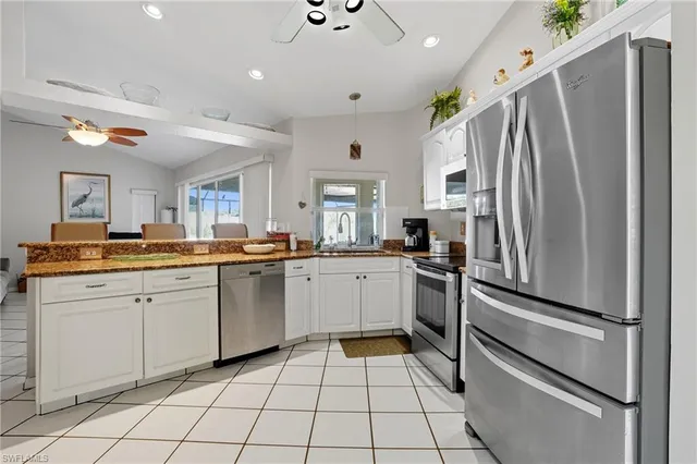 a kitchen with a refrigerator sink and cabinets