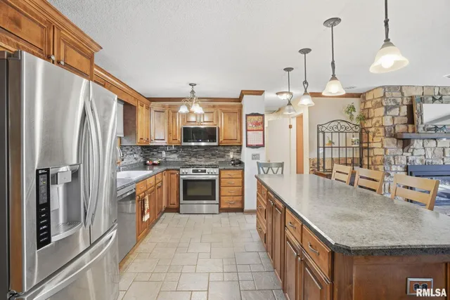 a kitchen with stainless steel appliances granite countertop a sink refrigerator and cabinets