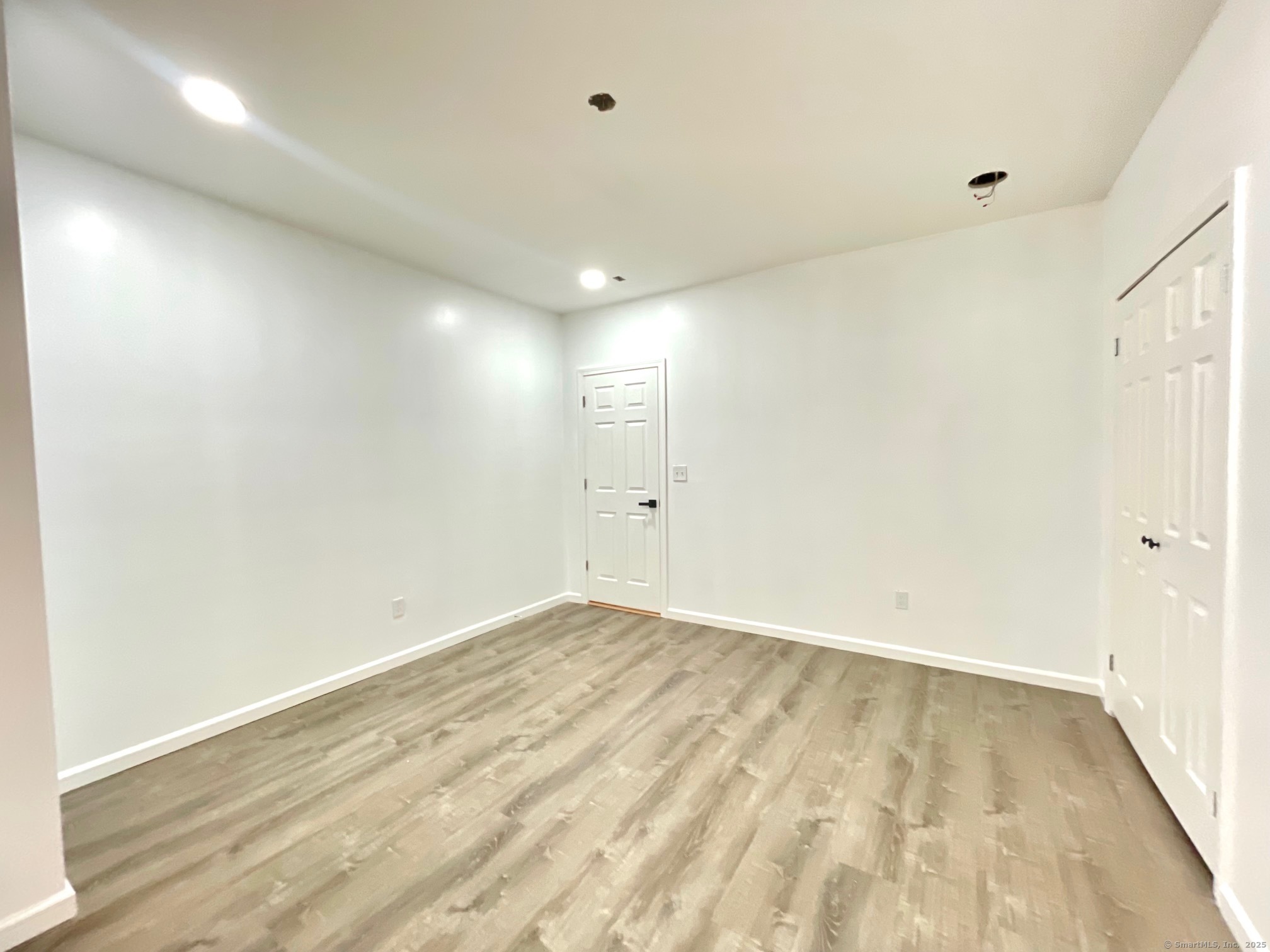 32 Lester Street Ansonia, CT 06401 - Photo 8 of 11 an empty room with wooden floor