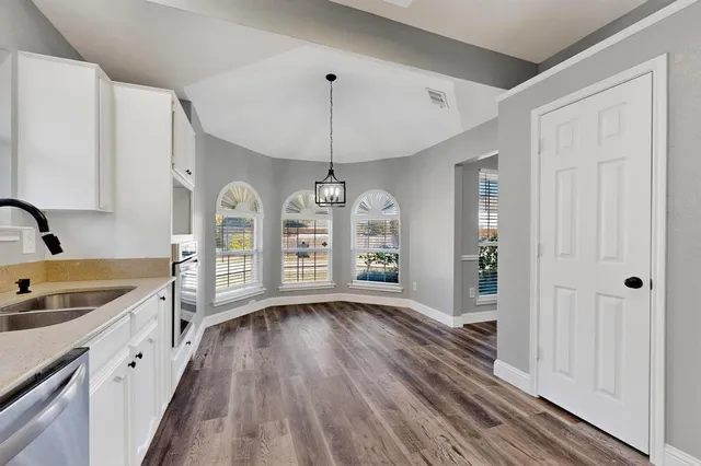 a view of a kitchen with a sink wooden floor and cabinets