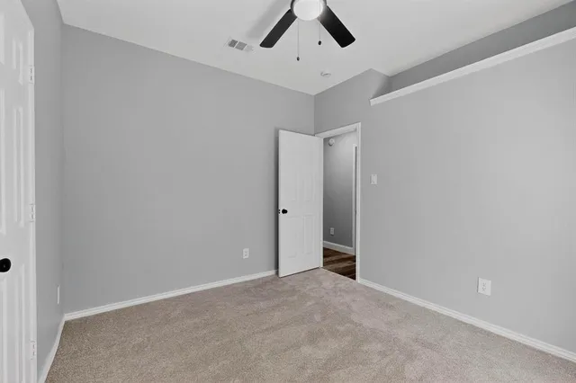 an empty room with chandelier fan
