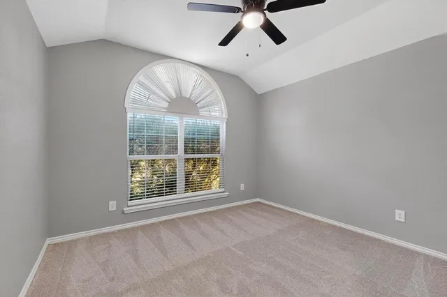 an empty room with a fireplace and windows