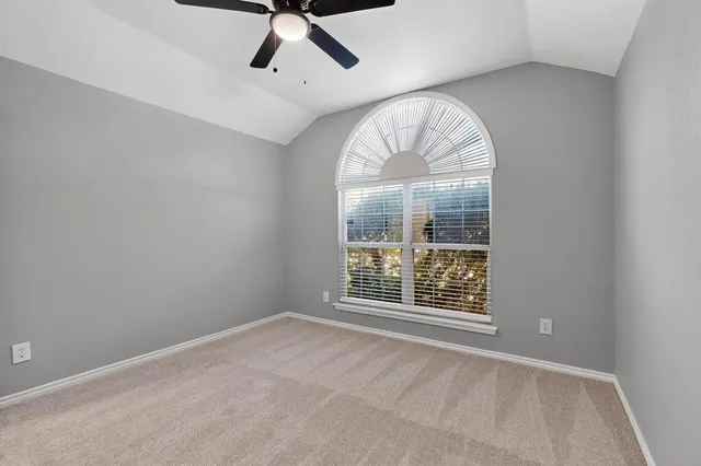 an empty room with chandelier fan