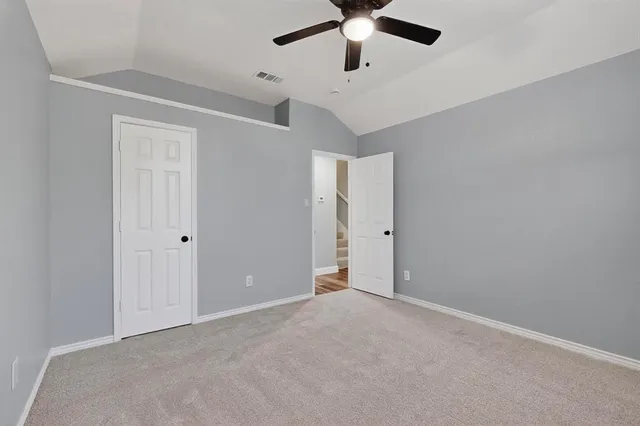 an empty room with a window and ceiling fan