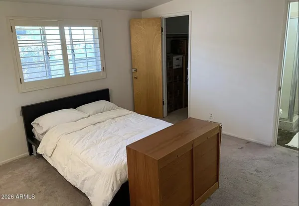 a bedroom with a bed and a window