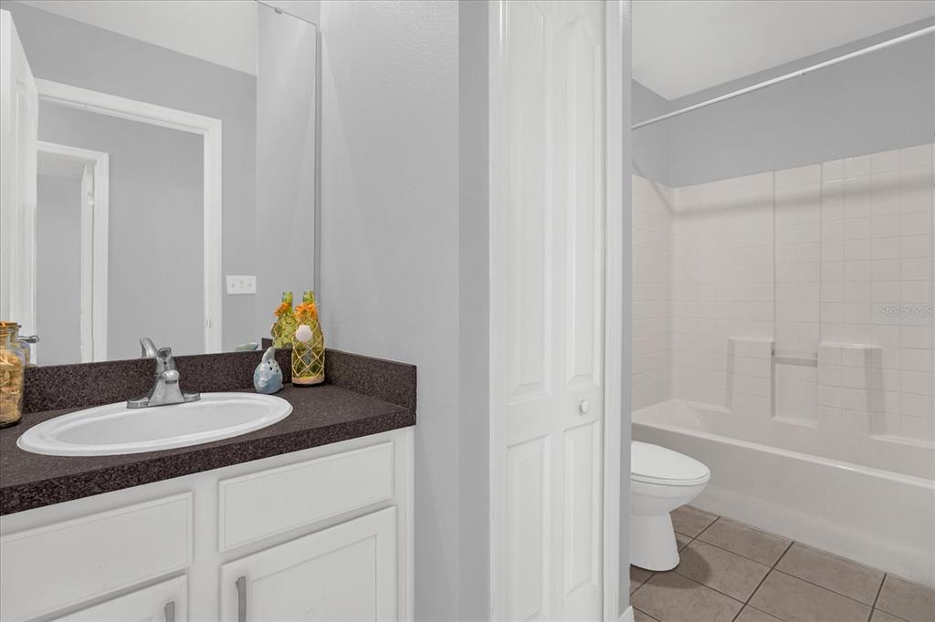 1453 Royal Ridge Drive Davenport, FL 33896 - Photo 14 of 32 a bathroom with a granite countertop sink toilet and shower