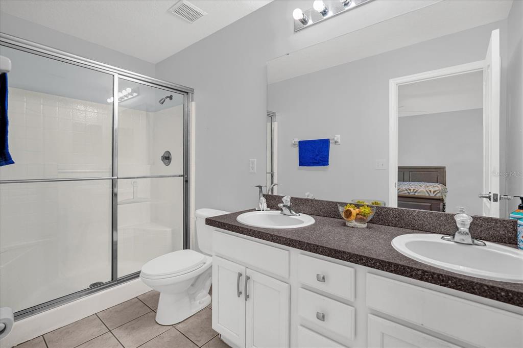 1453 Royal Ridge Drive Davenport, FL 33896 - Photo 19 of 32 a bathroom with a granite countertop sink mirror vanity and toilet