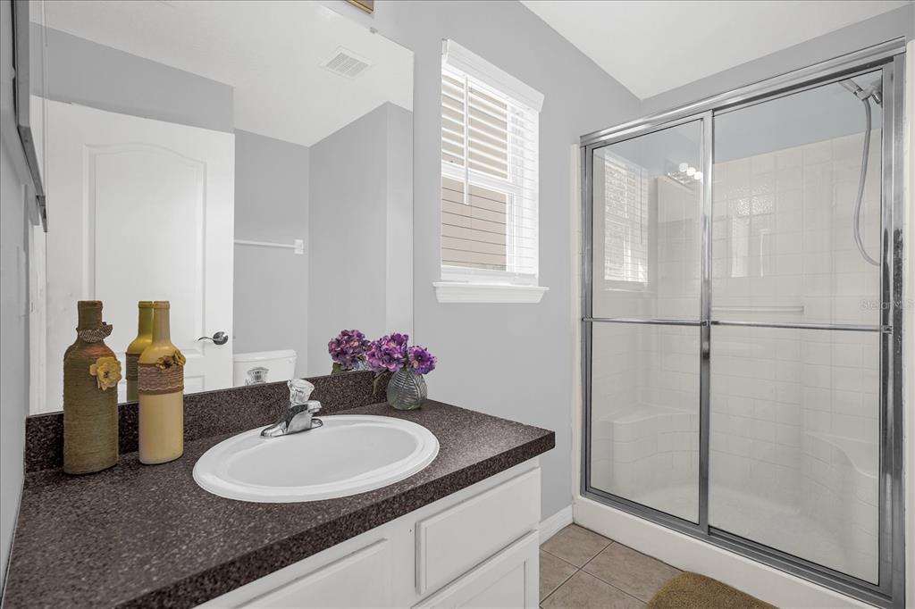 1453 Royal Ridge Drive Davenport, FL 33896 - Photo 22 of 32 a bathroom with a granite countertop sink and a mirror