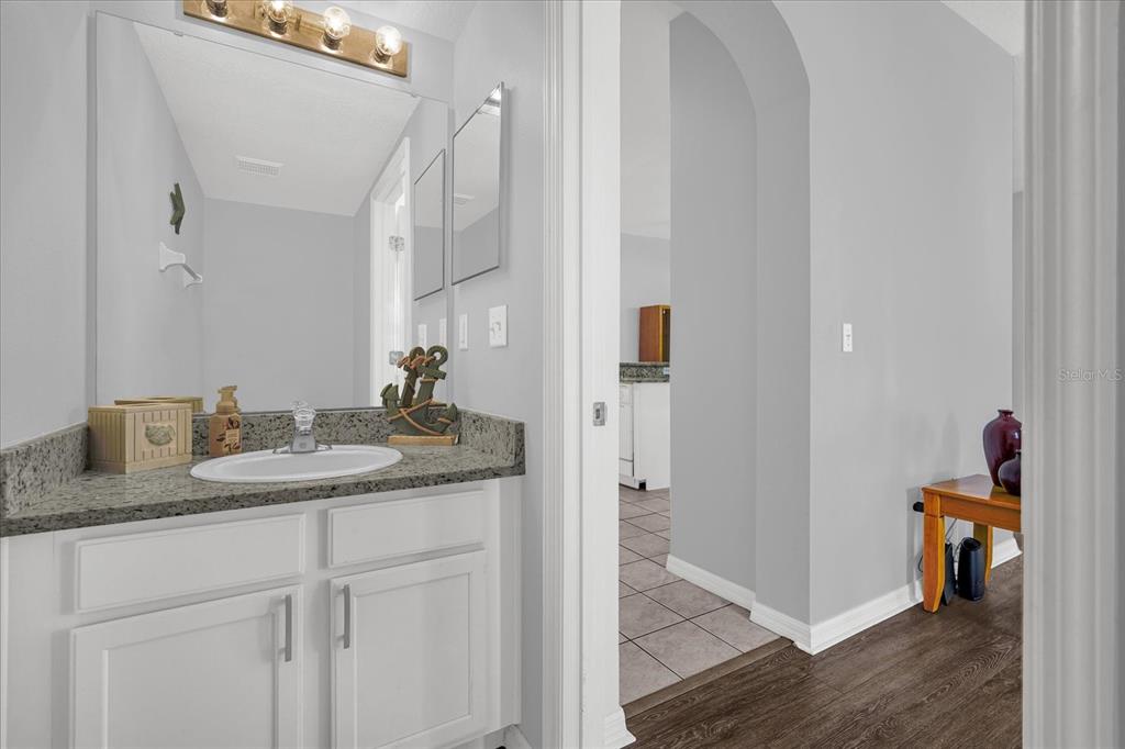 1453 Royal Ridge Drive Davenport, FL 33896 - Photo 23 of 32 a en suite bathroom with a granite countertop sink and a mirror