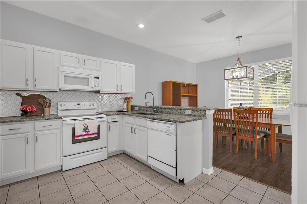 1453 Royal Ridge Drive Davenport, FL 33896 - Photo 3 of 32 a kitchen that has a lot of cabinets in it and appliances