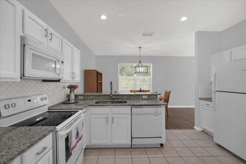 1453 Royal Ridge Drive Davenport, FL 33896 - Photo 4 of 32 a kitchen with a sink stove and cabinets