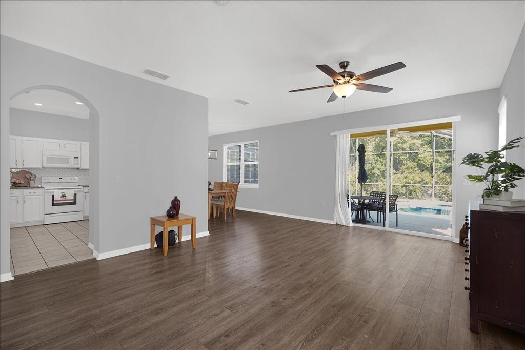 1453 Royal Ridge Drive Davenport, FL 33896 - Photo 8 of 32 a view of a livingroom with furniture hardwood floor a ceiling fan and windows