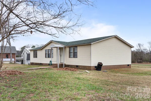 a front view of a house with a yard and large trees