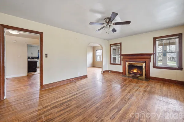 a view of empty room with wooden floor and ceiling fan