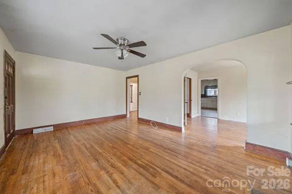 a view of empty room with wooden floor and entryway