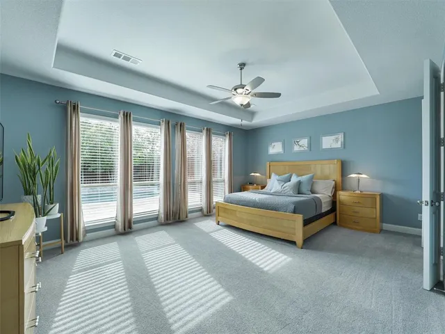 a bed sitting in a spacious bedroom next to a window