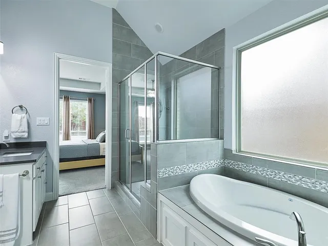 a en suite bathroom with a granite countertop tub and a sink