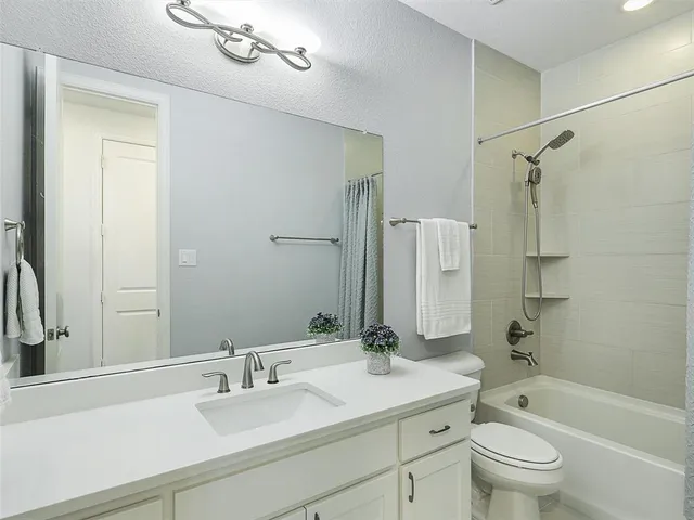 a bathroom with a sink a toilet and a large mirror
