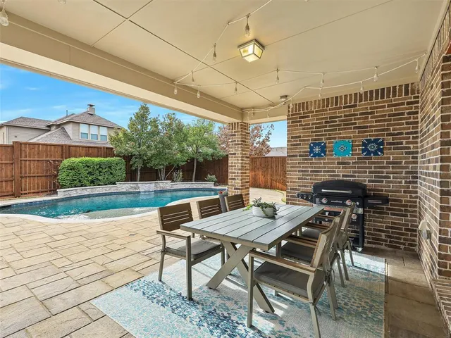 a roof deck with table and chairs and potted plants