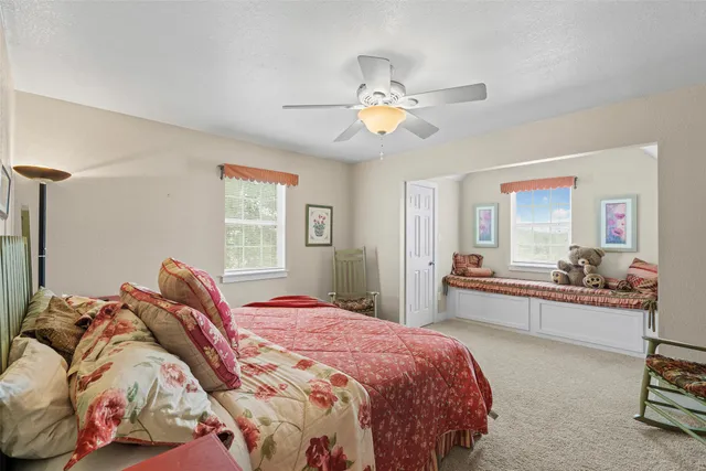 a bedroom with bed couch and window