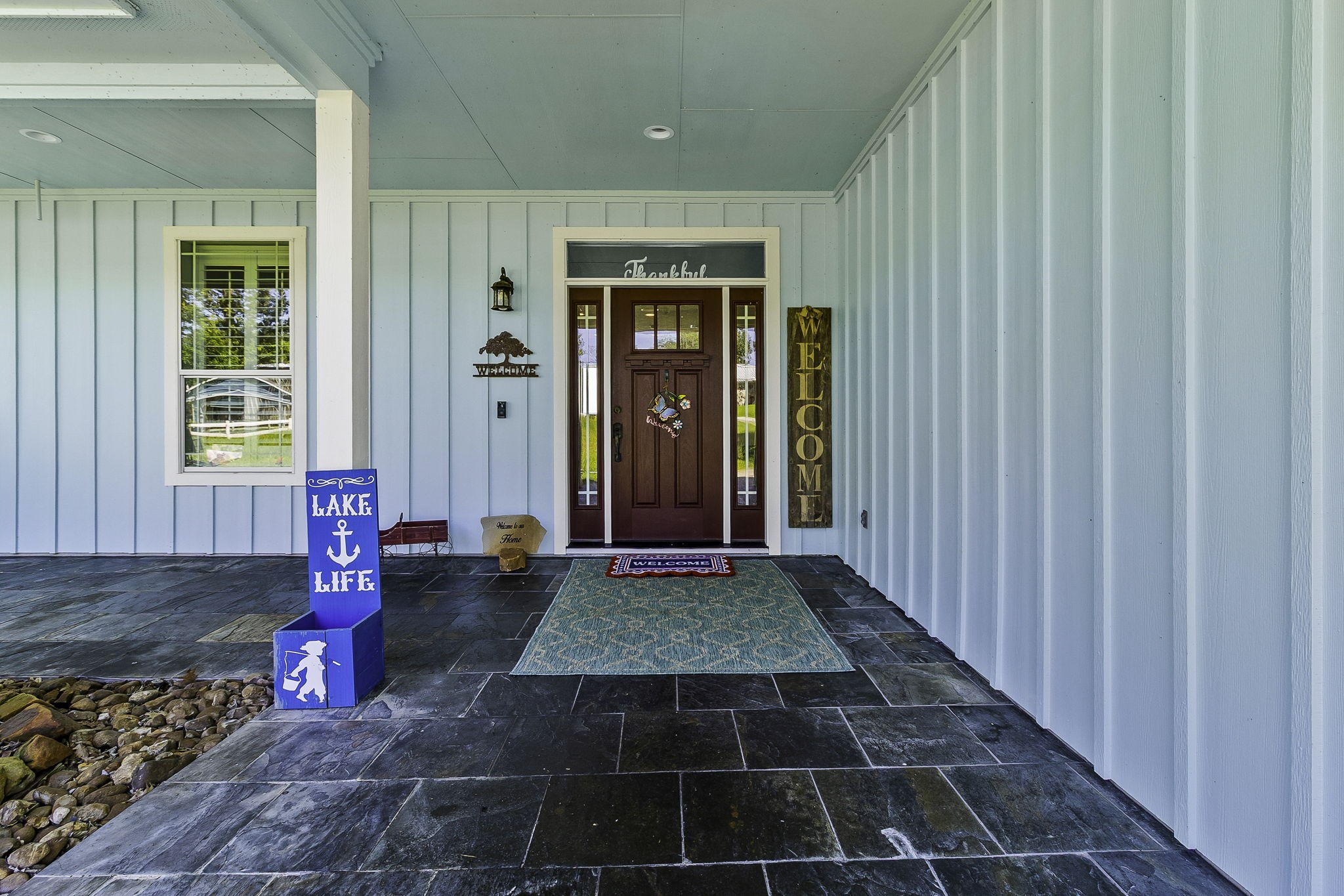 151 Key Largo Loop Point Blank, TX 77364 - Photo 4 of 49 Welcoming covered front porch with slate tile flooring, elegant wood entry door, and charming lake-inspired accents.