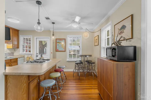 a dining room with wooden floor a chandelier a wooden table and chairs