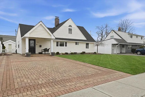a view of a house with a yard and large tree
